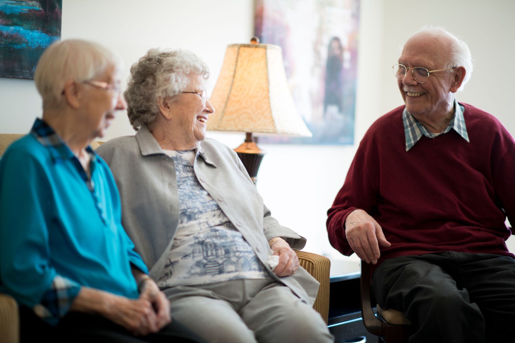 Seniors laughing together sitting down at assisted living community at Silver Birch