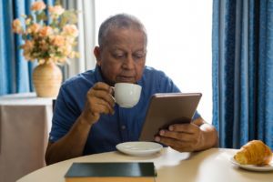 Elderly adult drinking a cup of coffee in assisted living at Silver Birch